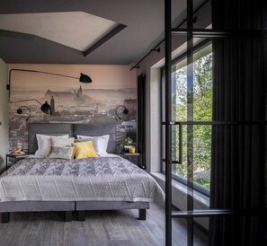 Ein modernes Schlafzimmer mit einem großen Bett, einer Stadtlandschaft-Wandmalerei, einem Oberlicht und einem großen Fenster mit Vorhängen.