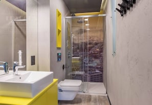 Une salle de bain moderne avec une douche à parois de verre, un lavabo blanc et des toilettes.