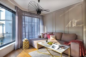 Un salón moderno con sofá, mesa de centro y vista a la ciudad.