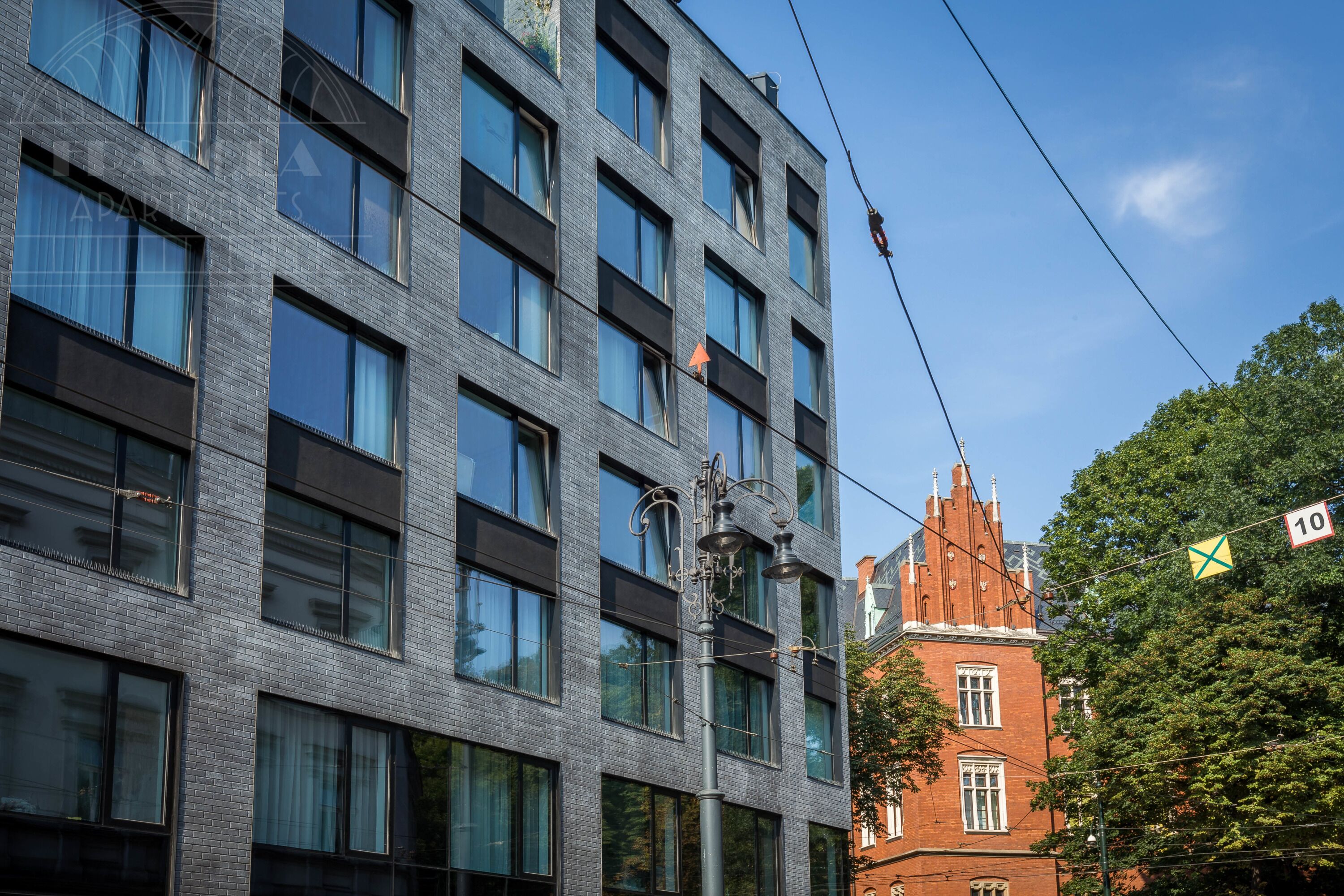 A modern building with multiple windows and a street lamp.
