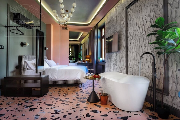 Una habitación de hotel moderna con una cama grande, una bañera y un diseño de suelo original.