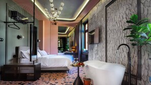 Quarto de hotel moderno com uma cama grande, uma banheira e um padrão de piso singular.