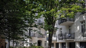 A multi-story building with balconies, a gated entrance, and a sign reading 'FRAGOLA APARTMENTS'.