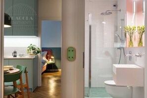 Une salle de bain moderne avec une douche à parois de verre, un lavabo blanc et des toilettes.