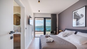 A modern hotel room with a large bed, a bathroom with a shower, a view of the sea, and a balcony. - Luxury Villa Spectrum pool 32m2 sauna, family, sea view, bbq (Posedarje)