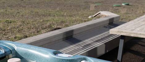Un jacuzzi con terraza de madera y vista al océano.