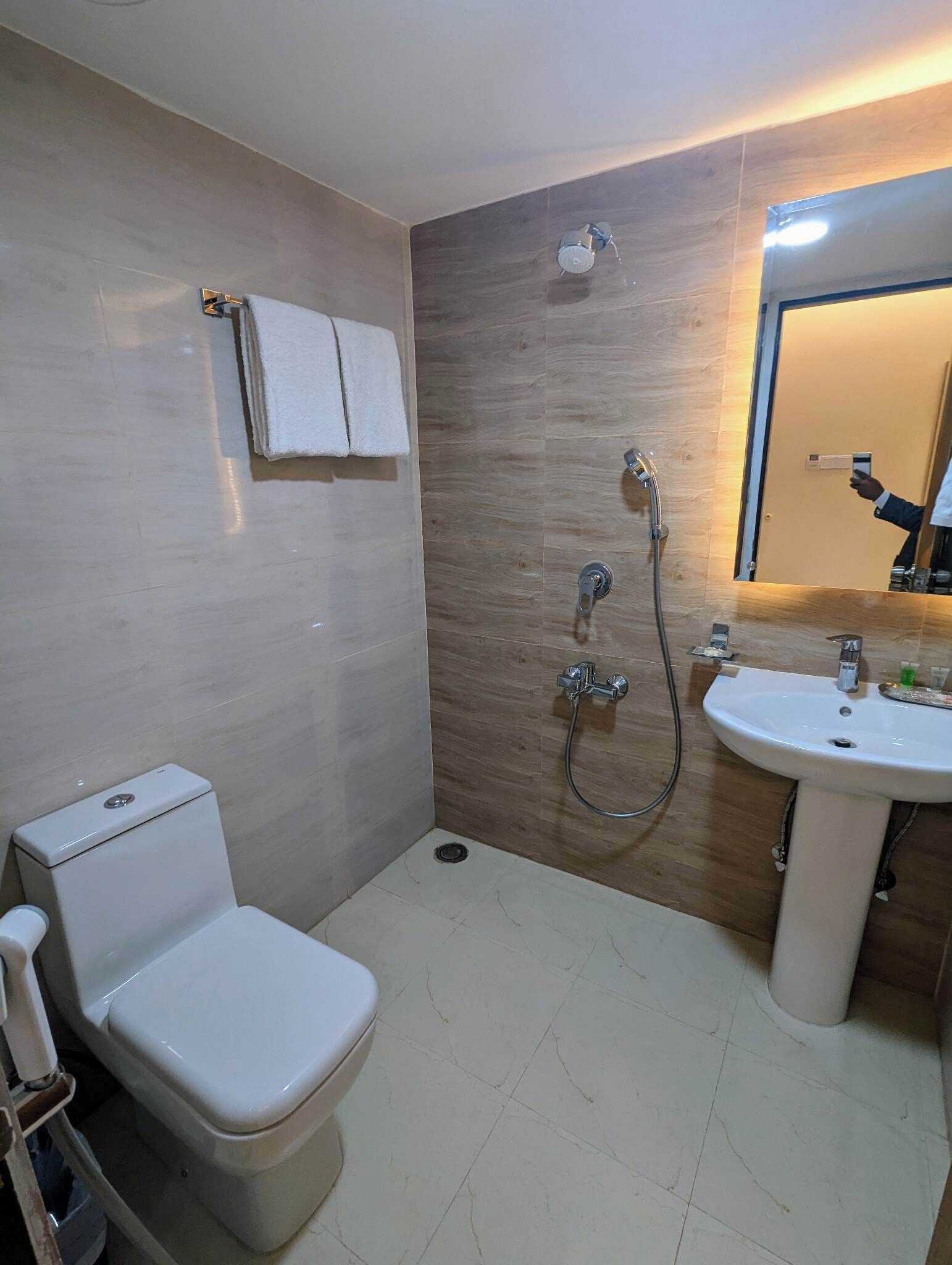 A small, modern bathroom with a toilet, a sink, and a shower.