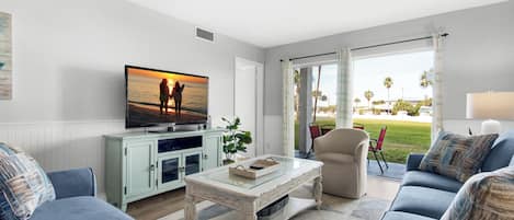 A living room with a television, sofa, and a coffee table.
