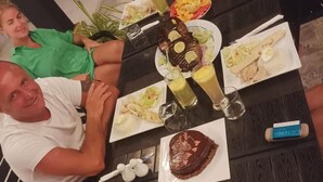 A dining table with various dishes and drinks, surrounded by people. - HI HEAVEN MALDIVES (Thoddoo)