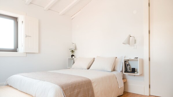 A minimalist bedroom with a bed, bedside tables, and a window. - Fontainhas Vista Douro by LovelyStay (Vila Nova de Gaia)