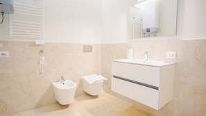 A modern bathroom with a bidet, a sink, and a mirror. - 18 Relais du Lac Elite (Desenzano del Garda)