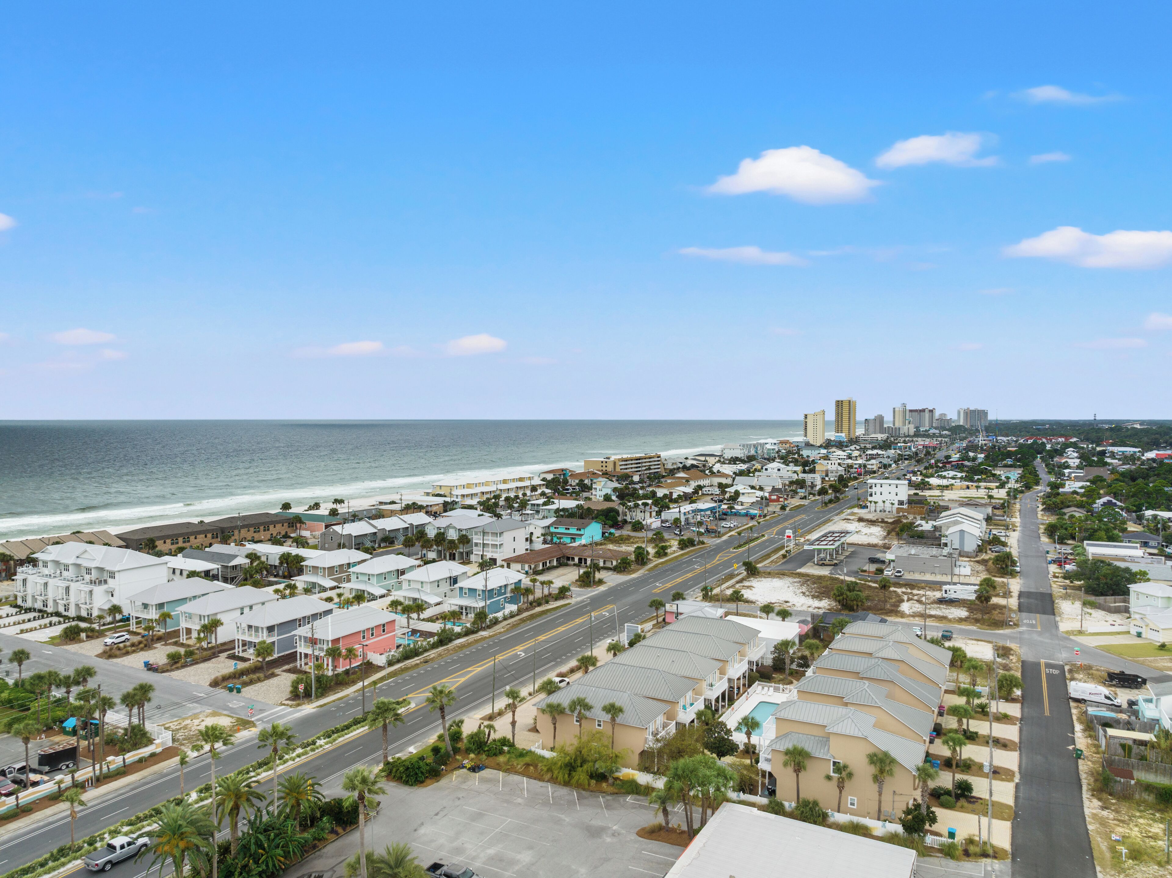 Un pueblo costero con playa, una avenida principal y edificios residenciales.