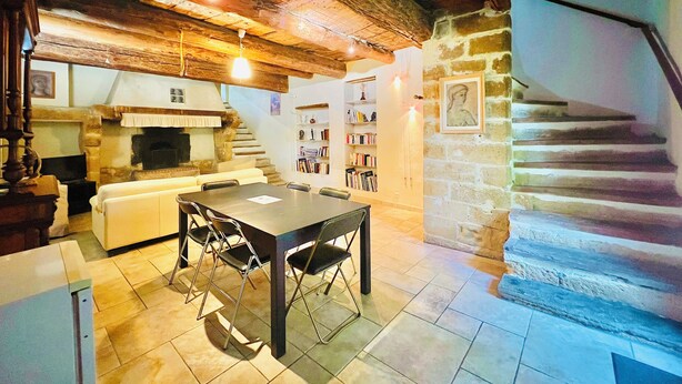 A rustic interior with a stone fireplace, a dining table with chairs, a staircase, and a bookshelf. - Le Moun Mazet 3-star self-catering accomodation, CLIM, Calm, Nature, 6 people, Provence (Miramas)