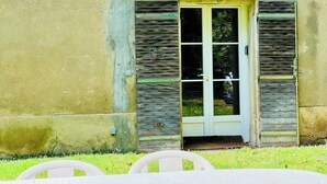 A building with a wooden door and shutters, a small porch area, and a concrete wall. - Le Moun Mazet 3-star self-catering accomodation, CLIM, Calm, Nature, 6 people, Provence (Miramas)