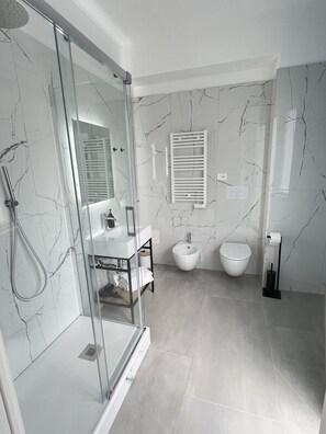 Kamer, balkon | Badkamer | Een douche, een haardroger, handdoeken, zeep