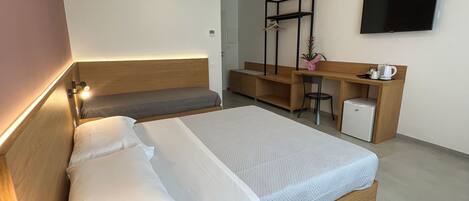Habitación triple Deluxe, baño privado | Escritorio, wifi gratis y ropa de cama