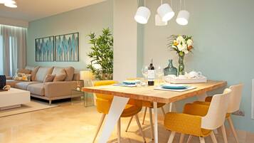 A modern dining area with a wooden table, yellow chairs, and a vase of flowers.