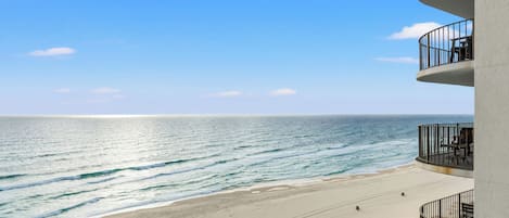 A beachfront hotel with a balcony overlooking the ocean.