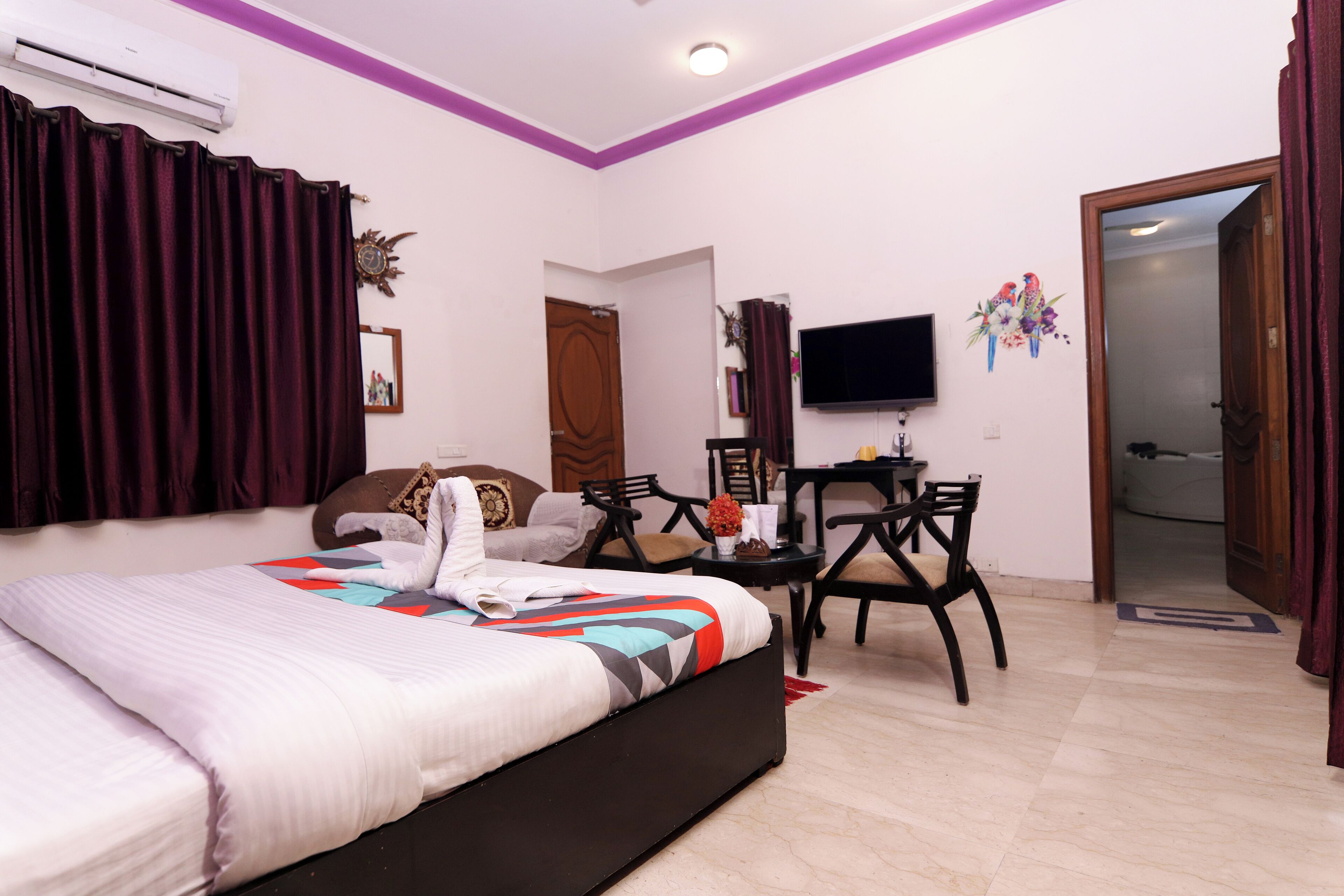 Una habitación de hotel con cama, escritorio, silla, televisor y puerta.