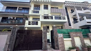 A multi-story residential building with balconies, a gated entrance, and a sign indicating sector 43. - Hotel Ashray Noida (Noida)
