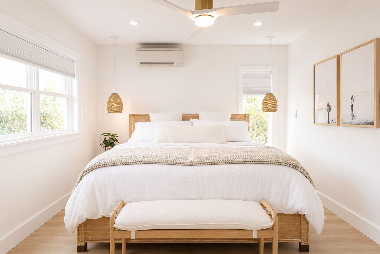 A bedroom with a bed, bedside lamps, a ceiling fan, and a window.