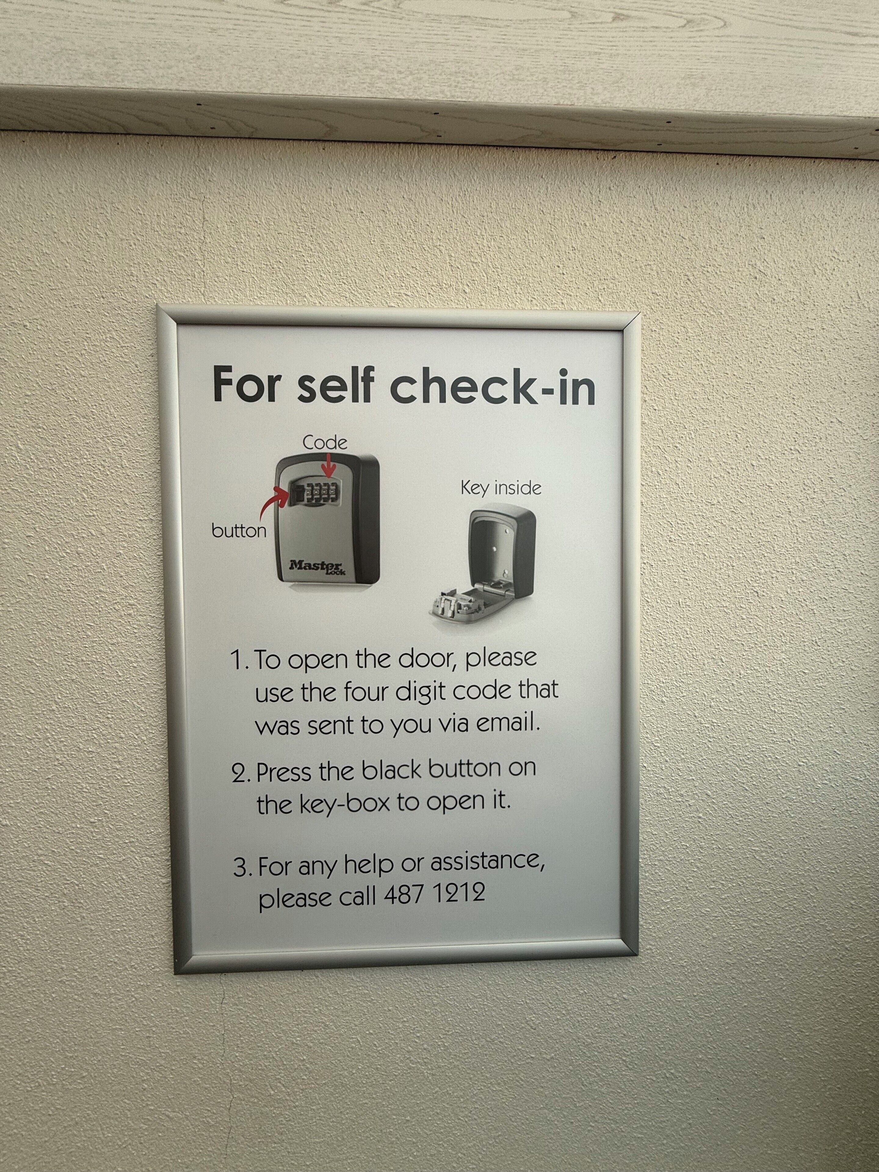 A self-check-in sign with instructions for using a code and a key box.