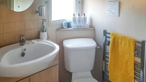 Un baño con lavabo, inodoro y toallero.