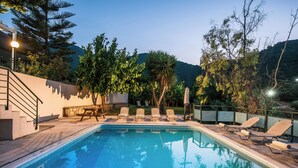 A swimming pool with lounge chairs and a staircase leading to a deck area. - Villa Vlychada w. Pool, Jacuzzi & Sea Views (9QXM+554 Vlichada, Greece)
