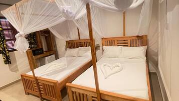 A room with two wooden beds, each with a canopy.