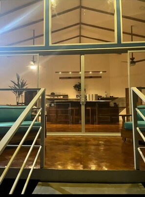 Enjoy a casual drink at the bar, surrounded by lush greenery and a modern atmosphere.