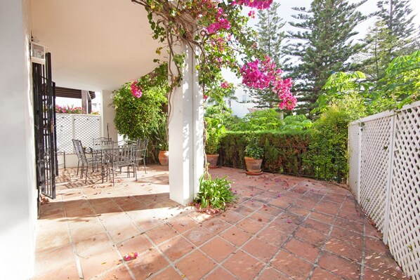 A patio with a tiled floor, a white column, and potted plants. - Apartment in Marbella Near the Beach (Marbella)