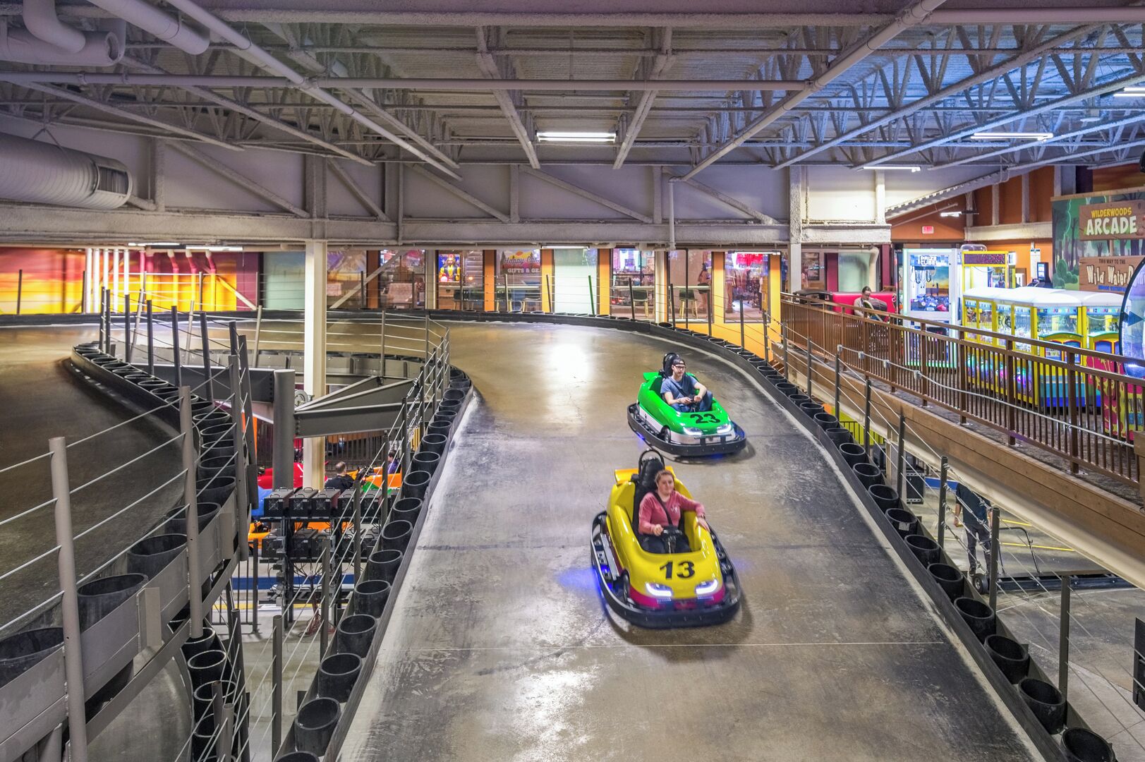 Une attraction d'intérieur comprenant une piste, des autos tamponneuses et des jeux d'arcade.