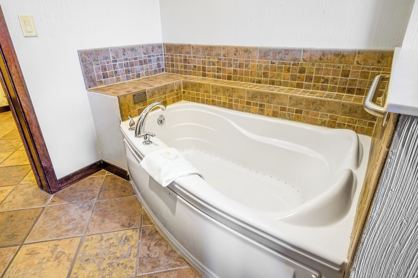 Un baño con una bañera independiente, un perchero para toallas y una zona de ducha con azulejos.