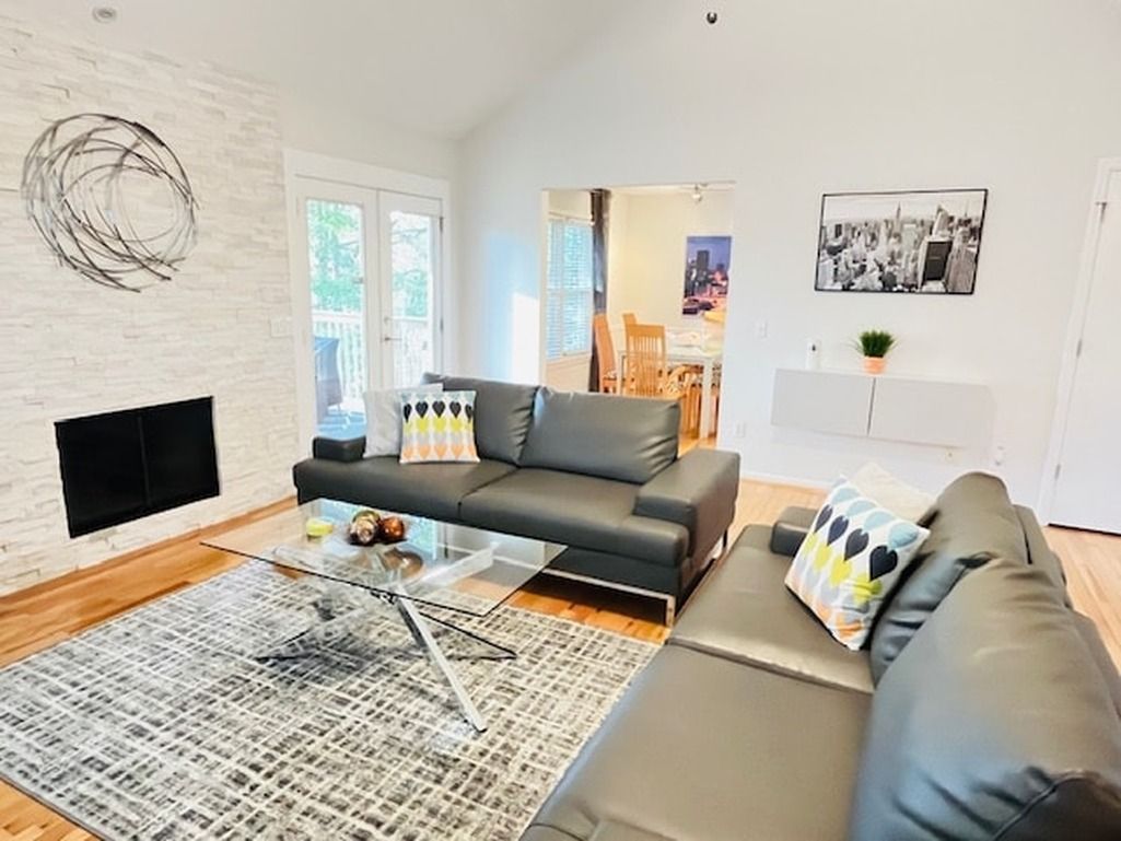 A modern living room with a sofa, a coffee table, and a fireplace.