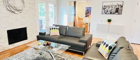 Un salon moderne avec un canapé, une table basse et une cheminée.