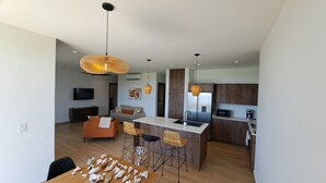A modern kitchen with a central island, wooden cabinets, and a built-in microwave. - Casa Bonita at Hermosa Bay, Chiriqui (Boca Chica)