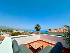 A balcony with a view of the sea and a mountain in the distance. - Casa Princesa Kristina (Manilva)