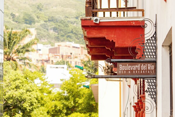 A sign for 'Boulevard del Rio Bed & Breakfast' with a view of buildings and trees in the background. - Boulevard del Rio Hotel (Cali)
