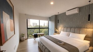 A modern bedroom with a large bed, a view of greenery outside, and a cityscape through the window. - Stylish Sky Suite /Daily Clean (Guadalajara)