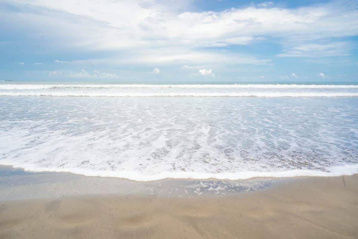 Una spiaggia con le onde che lambiscono dolcemente la riva.