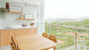 Eine moderne Küche mit Holzausstattung, einem Esstisch und einem Balkon mit Stadtblick.
