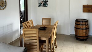 Zona pranzo con tavolo e sedie di legno, una ventola a soffitto, un orologio e una botte di legno.
