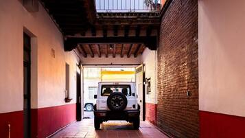A narrow alleyway with a white vehicle parked at the end.
