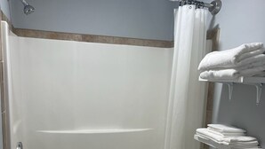 A bathroom with a bathtub, toilet, and a towel rack.