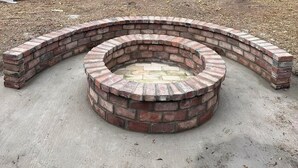 A circular brick fire pit with a concrete base, surrounded by a brick border. - Charming 2-bedroom house with AC and WiFi in lovely Wanette (Wanette)
