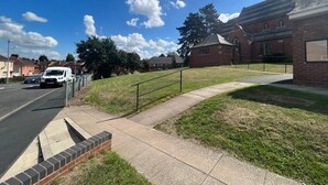 A residential street with a grassy area, a brick building, and a white van. - worcester Town home& Gardens (Worcester)