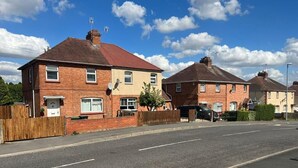 A residential street with two brick houses, each with a red roof and white-framed windows. - worcester Town home& Gardens (Worcester)