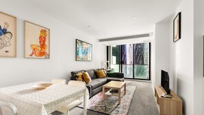 A modern living room with a sofa, coffee table, and TV stand.