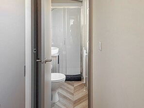 Ein Badezimmer mit Toilette, Waschbecken und Duschbereich.