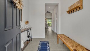 A hallway with a bench, a welcome sign, and a 'Gather' sign in the distance.
